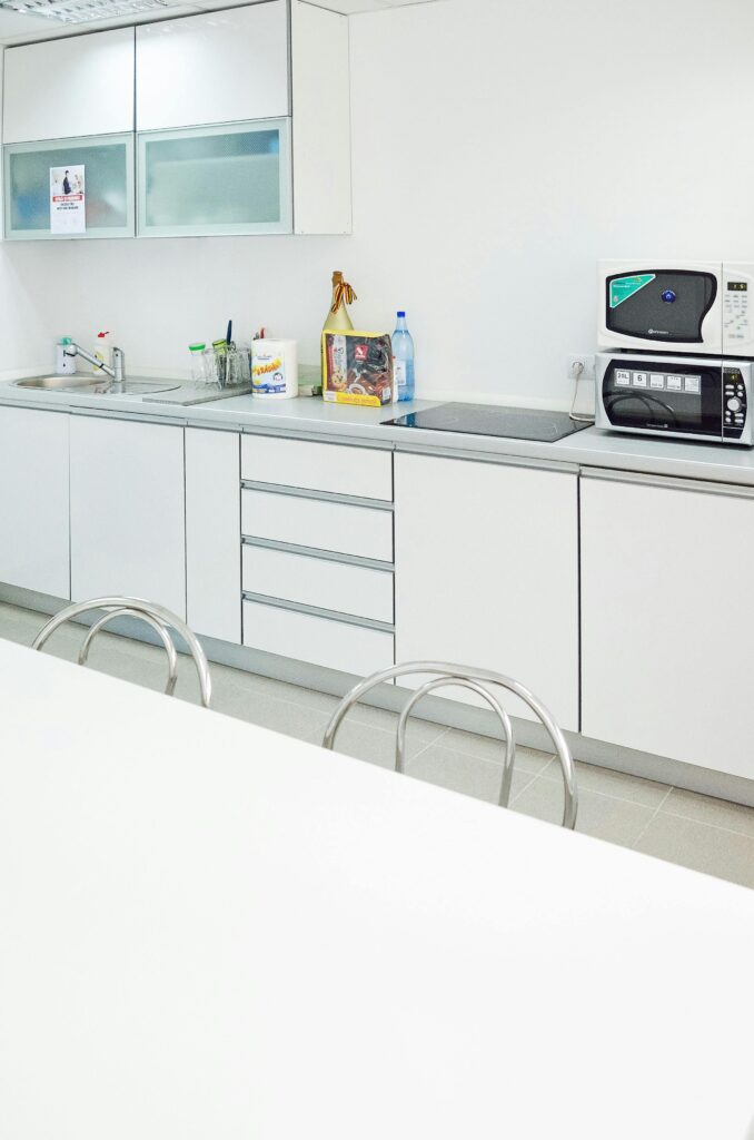 A sleek white kitchen interior featuring modern appliances and minimal design.
